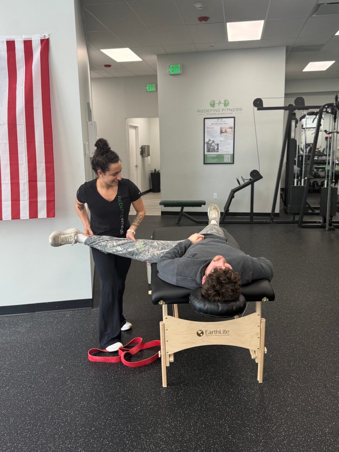 Assisted leg stretch with a strap, one on one with a Fitness Specialist