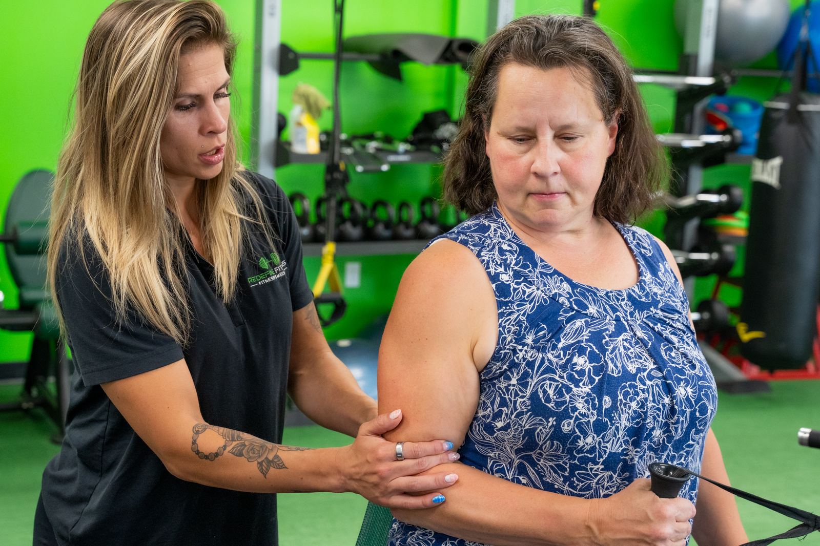 Fitness Specialist Amanda Leal coaching a client through resistance band work at Redefine Fitness