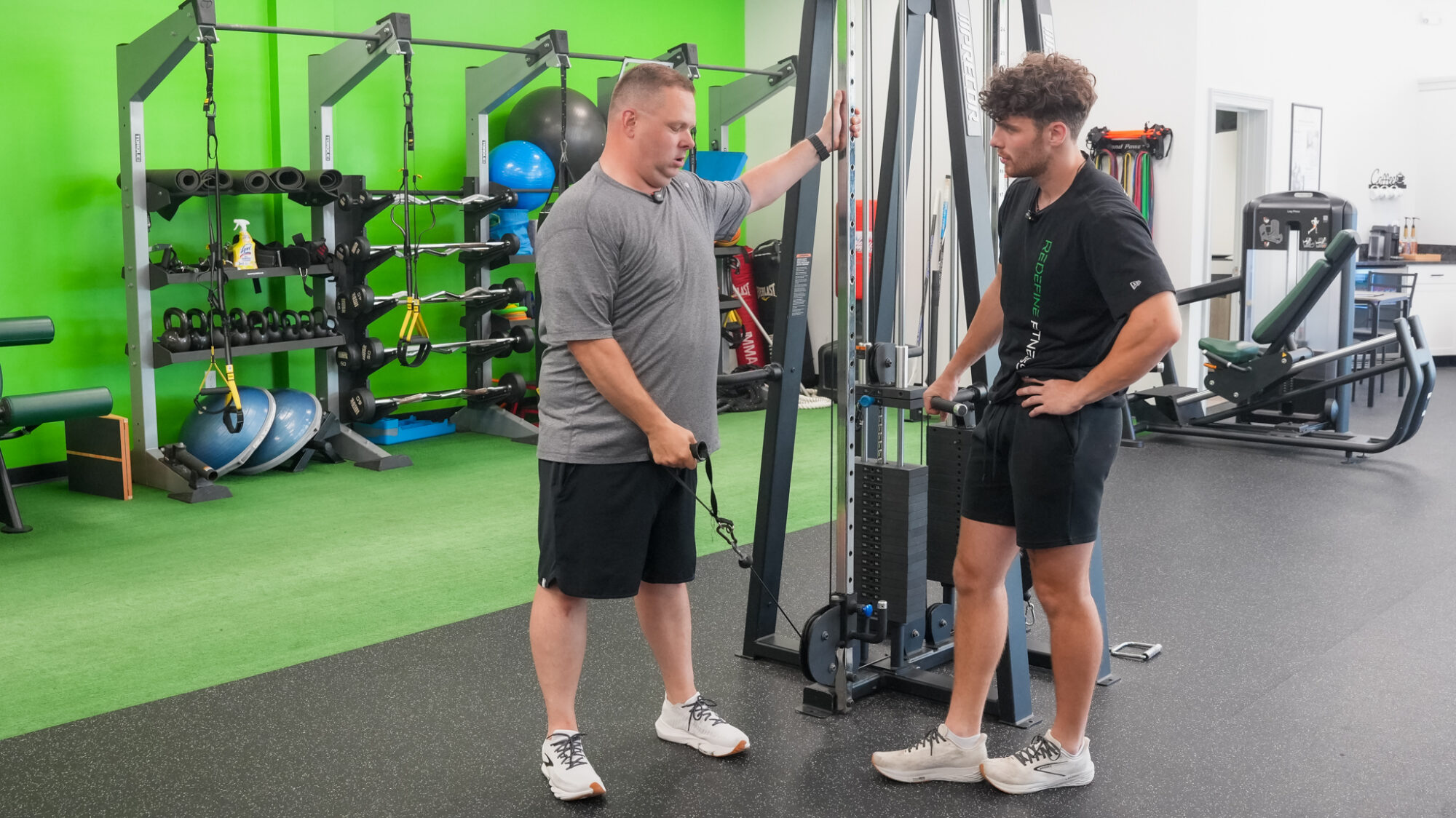 Fitness Specialist coaching a client at the cable station, one on one