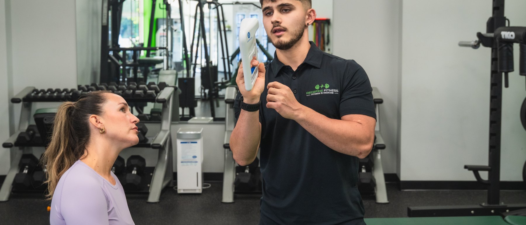 Fitness Specialist Tyler Flowers walking a client through her InBody results at Redefine Fitness Mount Sinai