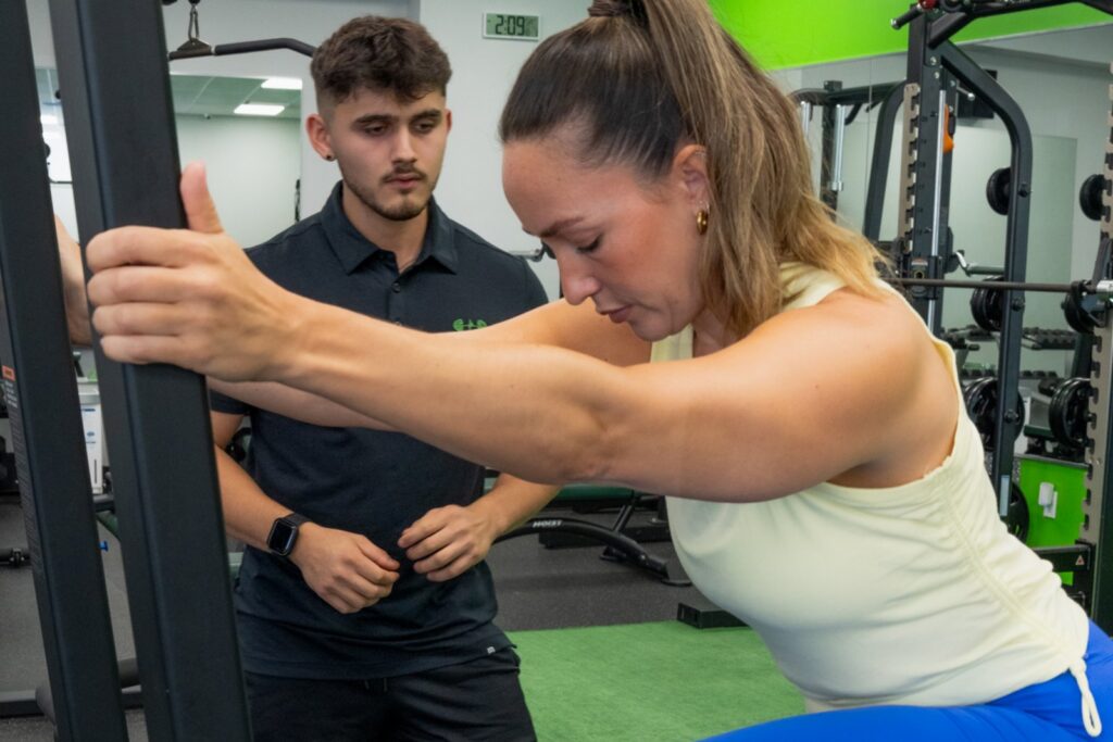 A Fitness Specialist coaching a client through a step up at Redefine Fitness Mount Sinai