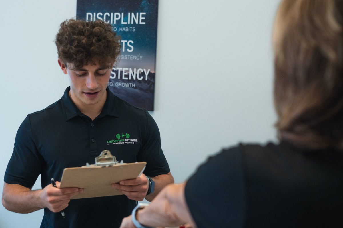 Fitness Specialist explaining screening findings to a client at Redefine Fitness